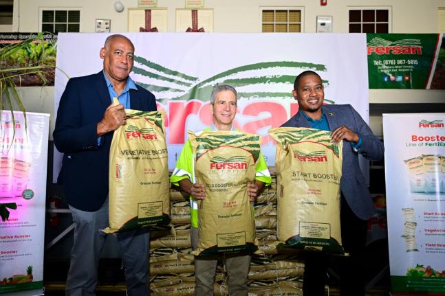 Minister of Agriculture, Fisheries and Mining, Floyd Green (right), shares in the symbolic handover of fertiliser by Newport-Fersan (Jamaica) Limited with the company’s Managing Director, Dennis Valdez (centre), and Chairman of the Agriculture Minist