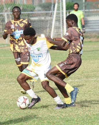 Ian Allen/photographer 
Excelsior High School’s Kimarly Scott (centre) tries to get past Charlie Smith’s Devonte Wilson during their ISSA/WATA Manning Cup quarter-final encounter at Winchester Park yesterday. Looking on is Charlie Smith’s Orlando Gra