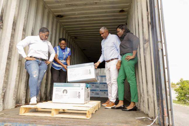 From left: Jannel Morrison, sales & marketing executive, Mabe; Marsha Burrell-Rose, manager – marketing, pr & missions, Food For The Poor; Philip Roach, commercial director, Unicomer; and Georgia Williams, purchasing manager, Courts, assist with the offl