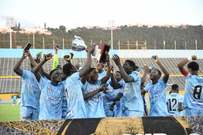 Members of the St Catherine High football team celebrate with the trophy after defeating defending champions Mona High in the Walker Cup KO final at the National Stadium yesterday. 