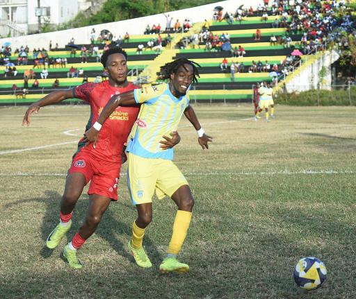 Waterhouse FC’s Omani Leacock (right) is challenged by Montego Bay United’s Richardo Ramsey during their Jamaica Premier League game at Jarrett Park yesterday.