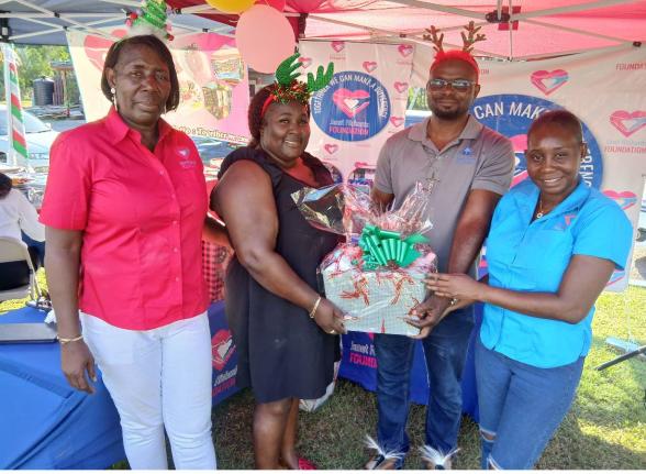 Cordell Howell-Huie (second left) and Deacon Dalmas Agan (second right)), administrators at the Mustard Seed Children’s Home in Moore Park, St James, jointly collect a gift basket from Janet Richards (left), chairman of the Janet Richards Foundation, and