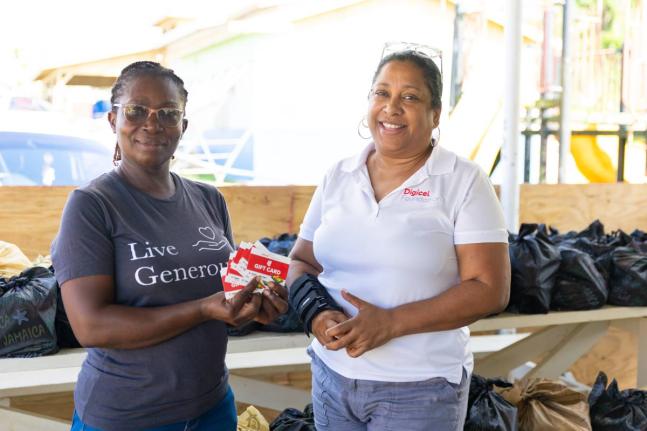 Digicel Foundation CEO Charmaine Daniels (right) hands over $300,000 worth of hardware vouchers to Sadie Brisstell, administrative assistant at West Haven Children’s Home, during a visit to the facility in Hanover. 