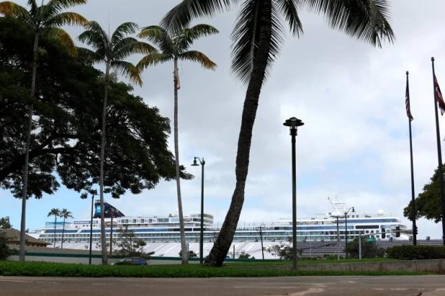 A cruise ship (in background) is docked in Honolulu, March 23, 2020.