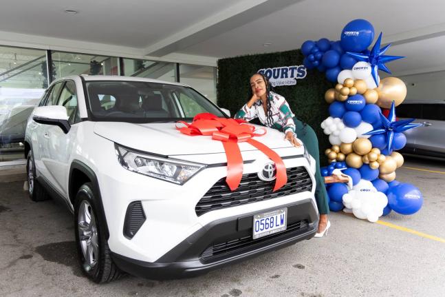 Carrie Davis, English Language teacher at Vere Technical High School, poses with her brand-new 2025 Toyota RAV4 during the official handover ceremony held on December 23, 2025, at Toyota Jamaica.