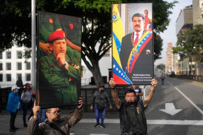 Government supporters display posters of Nicolás Maduro, right, and Hugo Chávez in downtown Caracas, Venezuela.