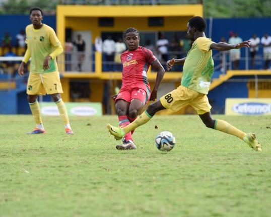 Montego Bay United’s Clarens Gilles (centre) is challenged by Treasure Beach FC’s Chandol Anderson during their Jamaica Premier League football game at St Elizabeth Technical High School on Sunday.