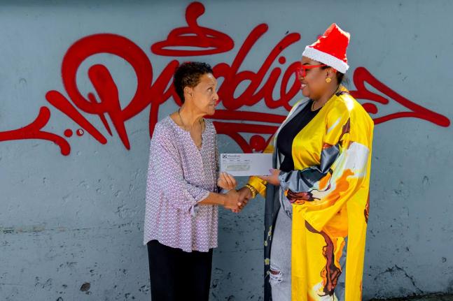Clover Reddie-Brown (left), director of Reddies Place of Safety, receives a donation cheque from Marathon’s Joseth Brown, manager of business development, marketing and public relations. Staff from the insurance brokerage fêted the wards at the facility