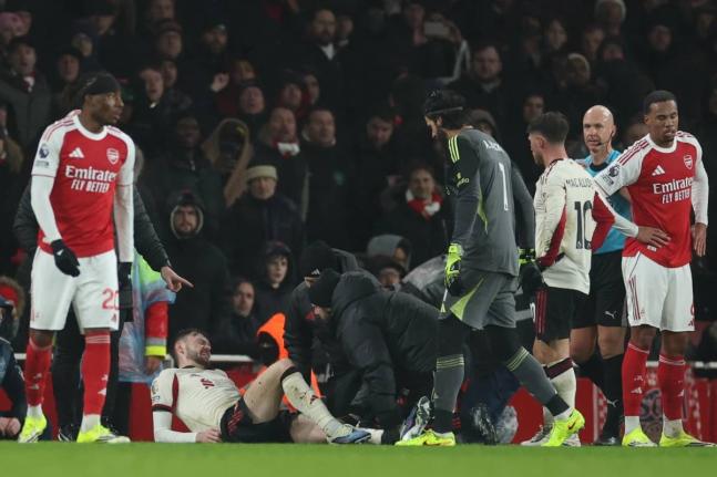 Trainers check on Liverpool’s Conor Bradley (second left)  during the English Premier League match between Arsenal and Liverpool in London, yesterday.