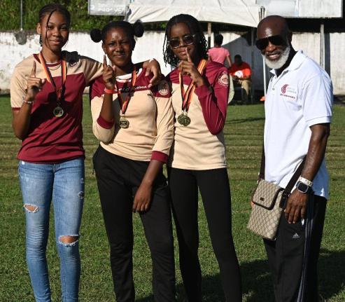 Comets Club International President Michael Campbell (right) poses with members of the Herbert Morrison Technical High School team after presenting them with medals at the second staging of the Run for the Republic development meet at the school on Saturda