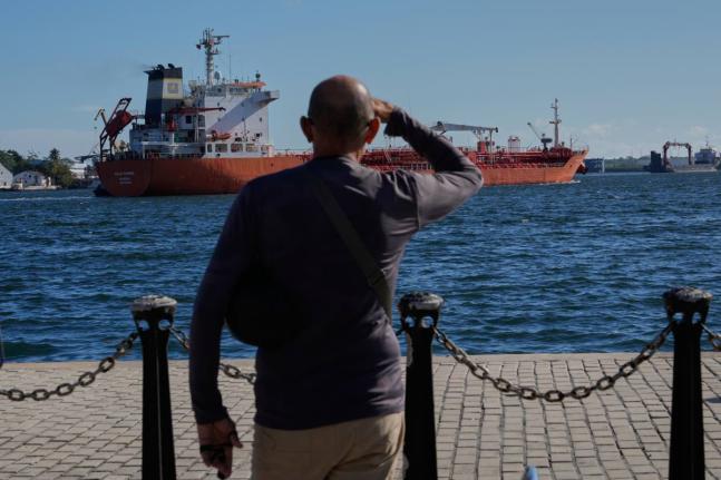 A man watches the oil tanker Ocean Mariner, Monrovia, arrive to the bay in Havana, Cuba.
