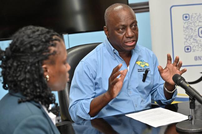 Audley Gordon, executive director of the National Solid Waste Management Authority (NSWMA), speaks to the media while Sheenique Johnson, corporate services director, looks on during an NSWMA press briefing on new operational measures to expedite debris rem