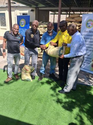 Chairman of the Jamaica Coffee Exporters Association (JCEA), Dr Norman Grant (4th left) inspects a bag of Newport Fersan fertiliser gifted to the association towards resuscitating coffee farms impacted by Hurricane Melissa. Also sharing in the occasion fro