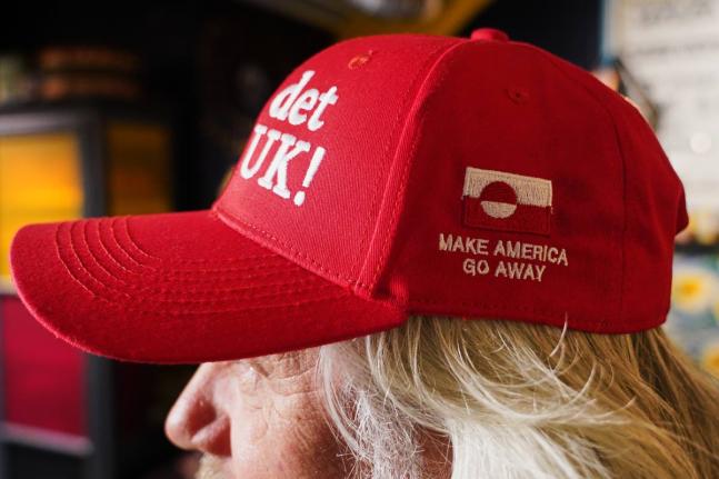 Store owner Jesper Rabe Tonnesen wears a red cap for sale that he created with the slogans "Make America go away," on the side, and on the front: "Nu det NUUK!," a twist on the Danish phrase “Nu det nok,” meaning “Now it’s enough,” substituting N