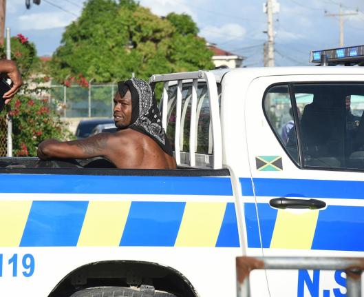 US-based Reggae Boy Corey Burke is taken away by members of the  Jamaica Constabulary Force outside the Ferdi Neita Park yesterday. Burke was detained following an altercation at the entrance to the  venue which was hosting the Portmore United versus Racin