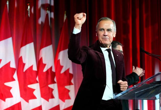 Canada's Prime Minister Mark Carney pumps his fist as he arrives to deliver remarks at the Liberal caucus holiday party in Ottawa.