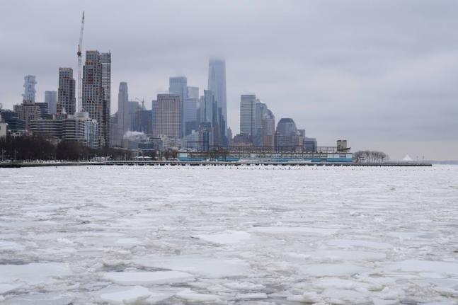 Clouds cover the top of One World Trade, top centre, as ice crowds the Hudson River in New York, Monday, January 26, 2026. (AP Photo/Seth Wenig)