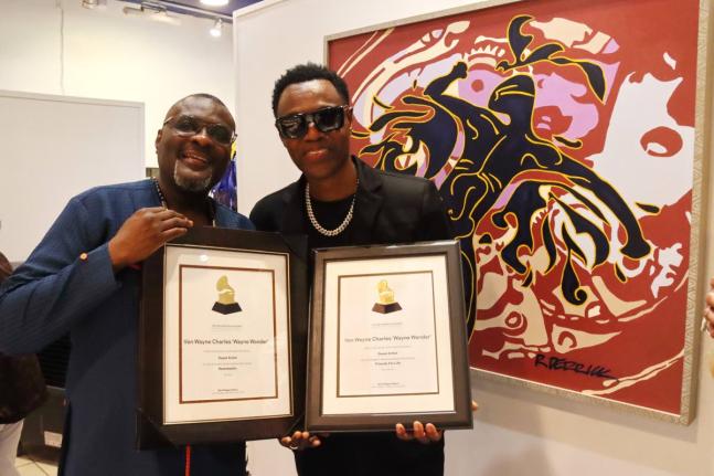 Wayne Wonder (right) and Kennedy Mensah of Back 2 Da Future Music Limited, showing off the Grammy certificates.