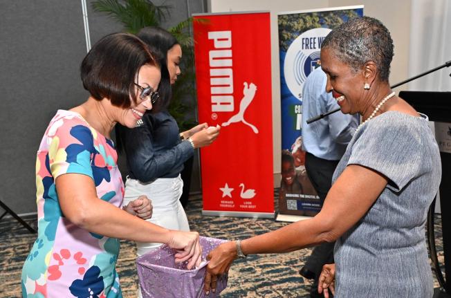 Simone Foote (left), marketing manager of BPM Financial Ltd and Genevieve Reid, member of the organising committee, during the draw for event sponsors at yesterday’s launch of the 2026 Gibson McCook Relays, at The Jamaica Pegasus Hotel in New Kingston.