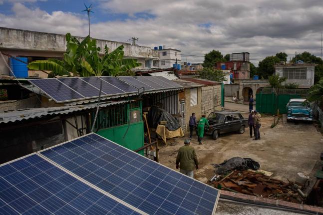 Solar panels cover the roof at the home of Felix Jose Morfi where mechanics push his broken down Lada car in Regla, Havana province, Cuba, Thursday, January 29, 2026. (AP Photo/Ramon Espinosa)