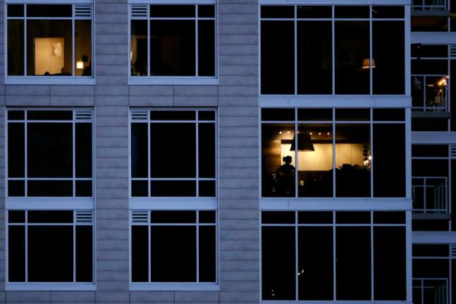A person looks out of a window in an apartment building in Kansas City, Missouri.