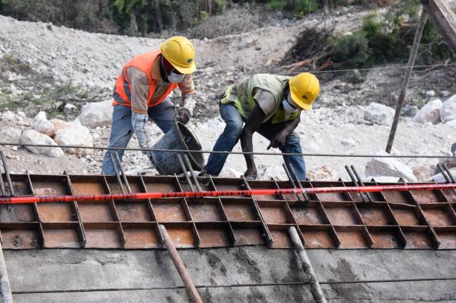 An employee of China Harbour Engineering Company Ltd (CHEC) constructs a retaining wall along the St Thomas main road in the vicinity of the Grants Pen community in 2020.