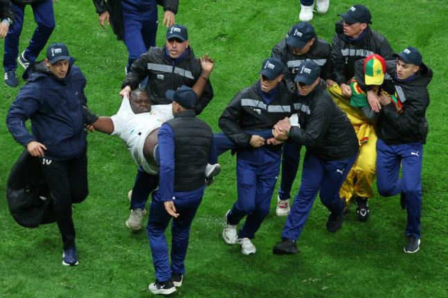 Senegal supporters are taken from the stadium by security officers after a controversial penalty was awarded to Morocco late on during the Africa Cup of Nations final footbal match in Rabat, Morocco on January 18.