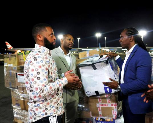 Alando Terrelonge (right), State Minister in the Ministry of Foreign Affairs and Foreign Trade, receives one of the packages from Nathaniel Peat (centre), GJDC UK Rep, and Jackson Smith, CEO of Fantasy Wings, both of whom organised the diaspora-led relief 