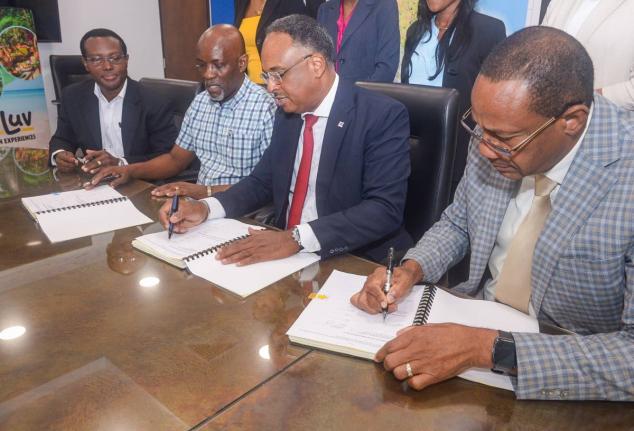 Jamaica Social Investment Fund (JSIF) Managing Director, Omar Sweeney (second right), affixes his signature to the contract to rehabilitate Bath Botanical Gardens in St Thomas, during a contract-signing ceremony on February 5 at JSIF’s Richmond Avenue of