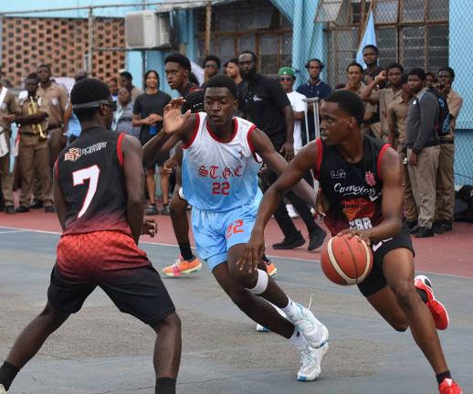 Zachery Lawrence-Smith (right) of Campion College dribbles past Imani Salmon (centre) of St George’s College during the ISSA urban Under 19 Basketball finals match at St George’s College on Tuesday.  Looking on at left is Dylon Kelly  from Campion Coll