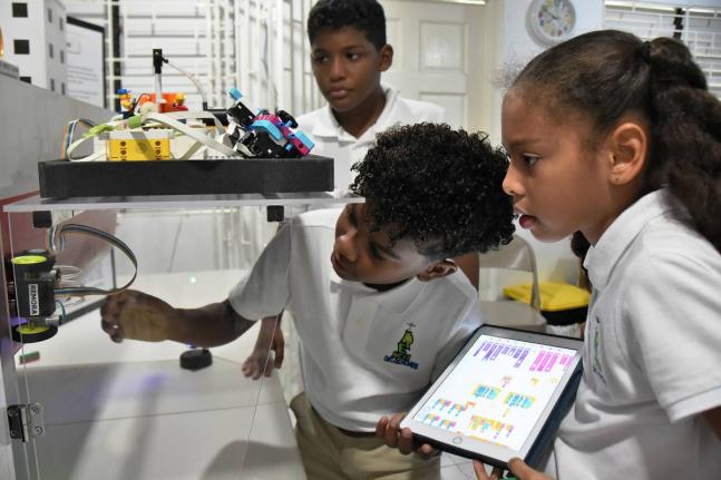 (From left): Jaxen Mitchell, Jacob Wong and Gia Whyms-Stone, members of Reach Academy robotics team, assembling a robot that won gold in the World Robotics Competition in 2024.