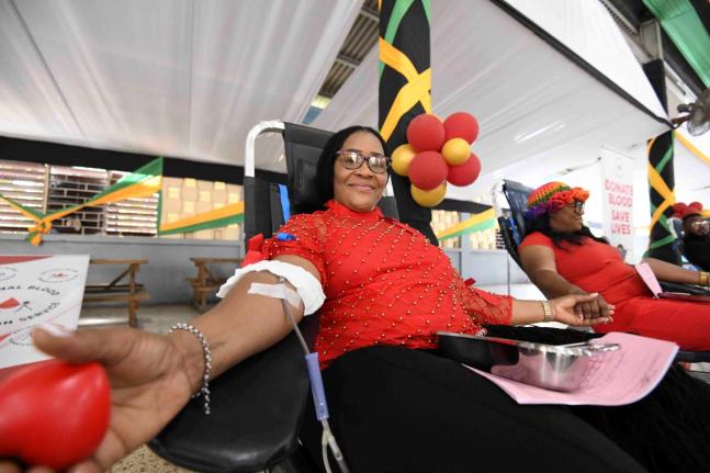 Sonya Binns-Lawrence, Jamaica’s top female blood donor, gives blood during her birthday blood drive, held on the grounds of Kencot Seventh-day Adventist Church in Kingston yesterday. 