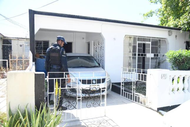 A policeman at a home in Breaton, Portmore, St Catherine where a woman was killed and her daughter injured in an attack on February 17.