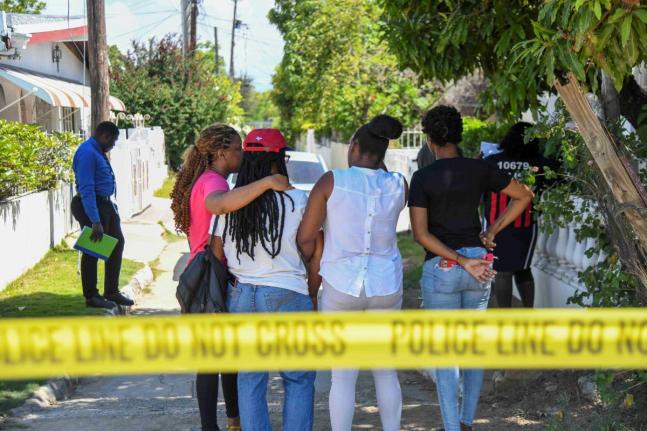 From left: Trudyann Bell Williams, niece; Carol Johnson’s twin sister; Yasheima Bell, niece and Toni-Ann Johnson, niece wait as police conduct investigations at Marlin Way, Braeton, Portmore where their relatives were attacked by a man believed to be of 