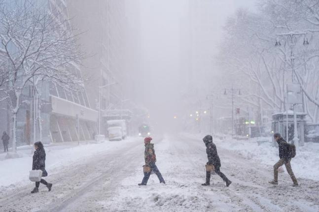 Pedestrians cross 42nd Street near Bryant Park during a snow storm, Monday, February 23, 2026, in New York. (AP Photo/Seth Wenig)