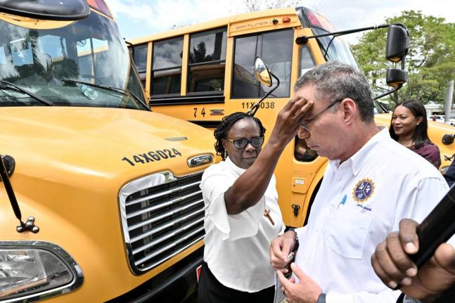 Bishop Christine Gooden-Benguche, president of the Jamaica Council of Churches, blessing Transport Minister Dary Vaz at a handover ceremony for the buses under the National Rural School Bus Programme last August.