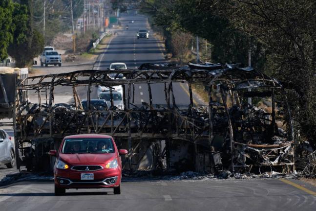 Vehicles drive past a charred bus the day after the Mexican army killed Jalisco New Generation Cartel leader Nemesio Oseguera Cervantes, known as ‘El Mencho’, in Guadalajara, Mexico, on Monday, February 23.