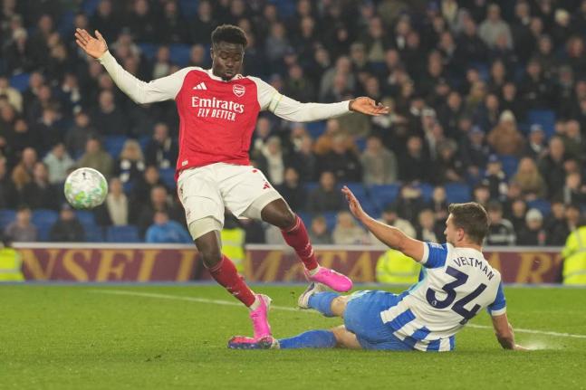 Brighton’s Joel Veltman (right) tackles Arsenal’s Bukayo Saka during the Premier League match in Brighton, England, yesterday.