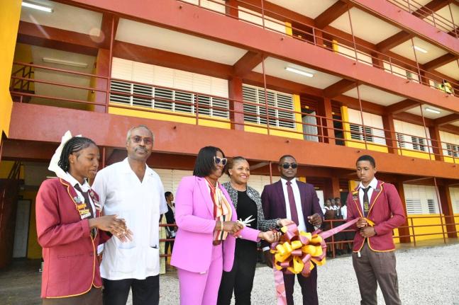 Education Officer for Region 5, Ministry of Education, Skills, Youth and Information,  Marsha Fennell-Bell (third left), cuts the ribbon to officially hand over the new 11-classroom block at Holmwood Technical High School in Manchester on Monday. Sharing i