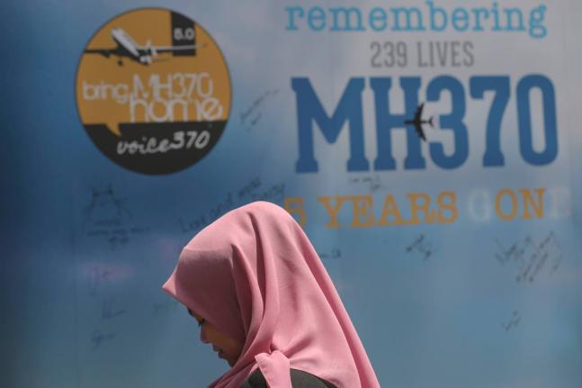 A girl stands in front of a condolence message board during a Day of Remembrance for MH370 event in Kuala Lumpur, Malaysia.
