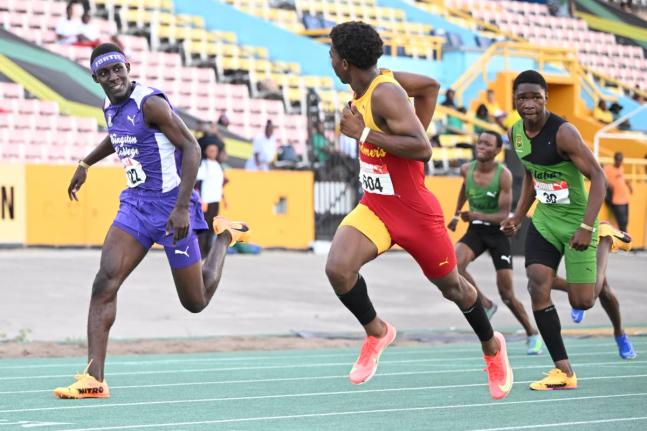 Mark-Daniel Allen (second from left) of Wolmer’s Boys’ glances at  Kingston College’s Brandon Bennett (left) as he powers to the line to win the boys’ under-17 110 metres hurdles  in 13.57 seconds at the Carifta Trials yesterday. 