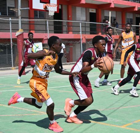Herbert Morrison Technical High’s Tyler Linton (right) tries to dribble away from Manchester High’s Waine Green Jr during their ISSA Schoolboy Under-16 Basketball Game One at the Herbert Morrison court on March 2.