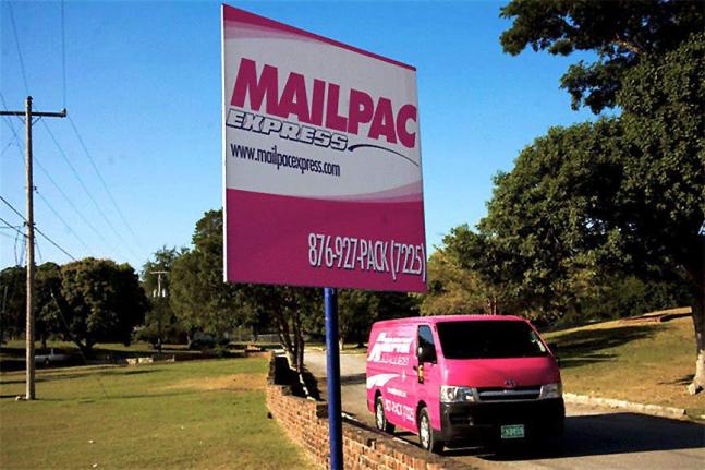A sign and delivery van branded in Mailpac colours.