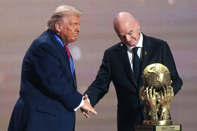 FIFA President Gianni Infantino (right) presents President Donald Trump with the FIFA Peace Prize during the draw for the 2026 football World Cup at the Kennedy Center in Washington on Friday, December 5, 2025. 