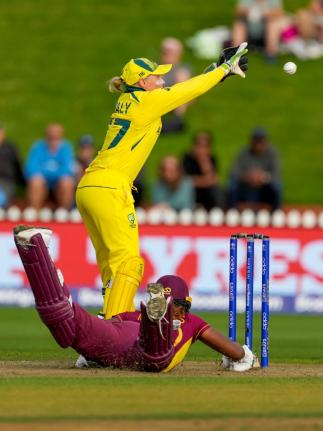 Alyssa Healy of Australia (top) takes a return throw as Hayley Matthews of the West Indies slides to make her ground during their Women’s Cricket World Cup semi-final match in Wellington, New Zealand, on March 30, 2022.