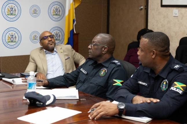Town Clerk Robert Hill (left) looks on during a recent Kingston and St Andrew Municipal Corporation meeting. 