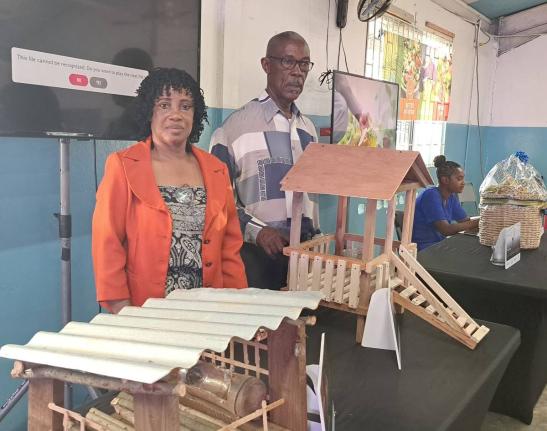 Kitson Town goat farmers Georgen Williams and Raymond Latibeaudiere, who are FAO beneficiary farmers, displaying a prototype of their goat house on March 26, 2026.