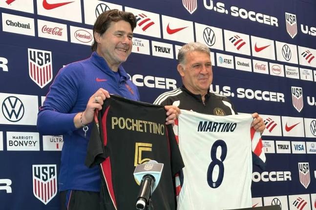 United States coach Mauricio Pochettino (left) and Atlanta United coach Tara Martino pose with jerseys during a news conference before the men’s national  team training yesterday in Marietta, Georgia.