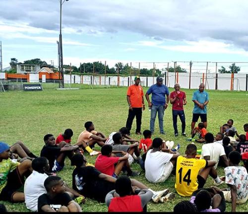 Members of the Jamaica Diaspora Football Association (JDFA)  (top, from left) Colonel Bruce Bartlett, Raymond Anderson, coach Calvin Salmon and president Michael Barnes address young footballers at the JDFA grassroots camp at the Edward Seaga Sports Comple